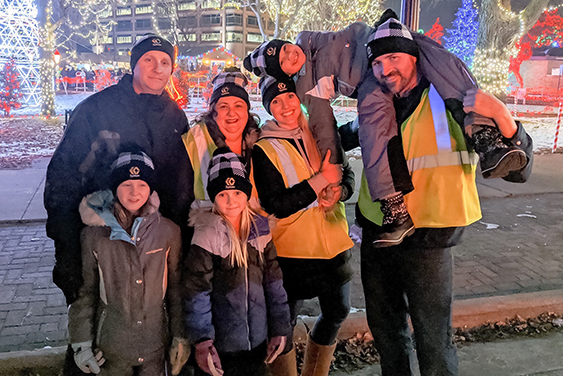 IC System Employee volunteers pose with children at the Rotary Lights display